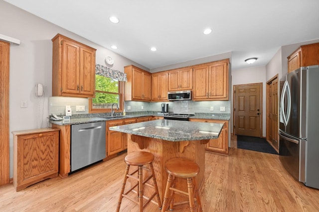 N66W13568 Crestwood Dr, Menomonee Falls, WI 53051 - kitchen featuring stainless steel appliances, a sink, light wood finished floors, a breakfast bar, and recessed lighting