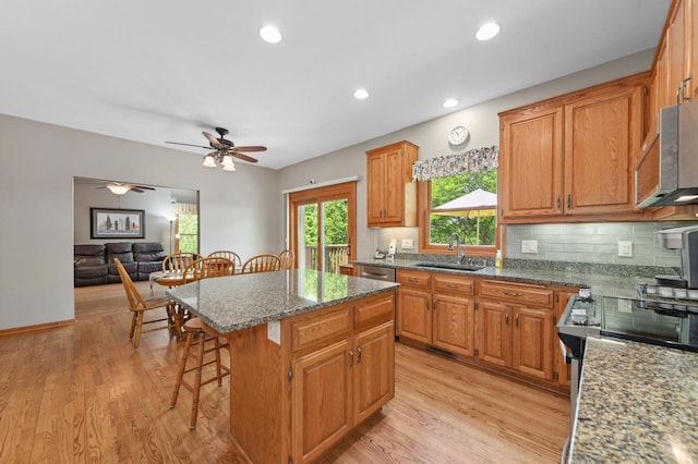 N66W13568 Crestwood Dr, Menomonee Falls, WI 53051 - kitchen featuring a sink, a kitchen bar, appliances with stainless steel finishes, light wood-type flooring, and a center island