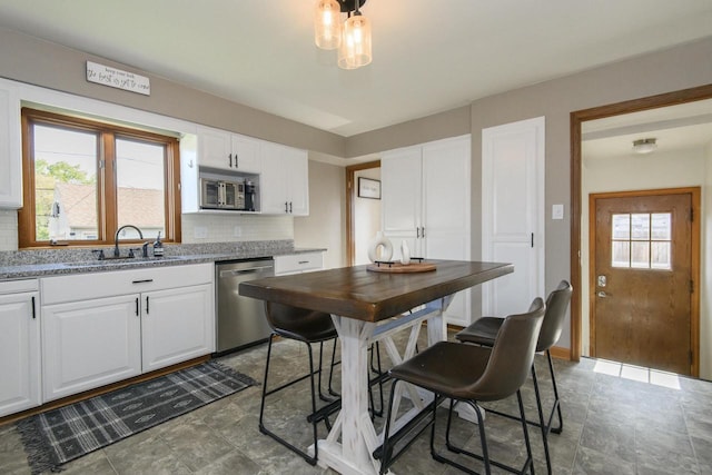 1638 Monroe Ave, South Milwaukee, WI 53172 - kitchen featuring stainless steel appliances, a sink, backsplash, white cabinetry, and light stone counters