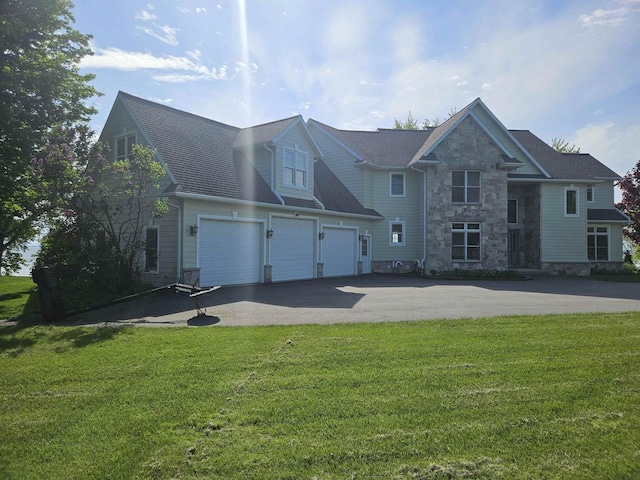N2281 Lakewood Ln, Chilton, WI 53014 - view of front of property with asphalt driveway, stone siding, an attached garage, and a front yard