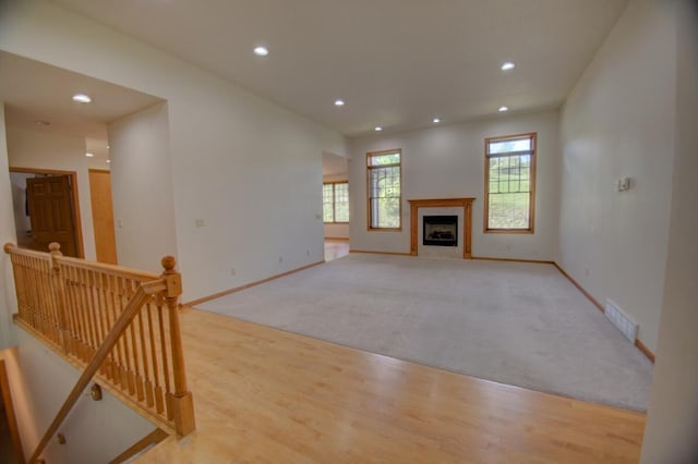 1835 Alpine Pl, Onalaska, WI 54650 - unfurnished living room with baseboards, recessed lighting, wood finished floors, and a tiled fireplace