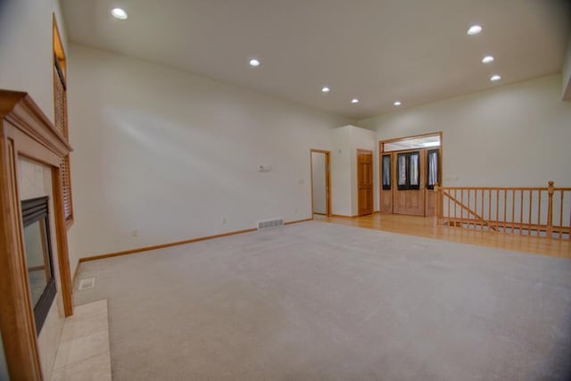 1835 Alpine Pl, Onalaska, WI 54650 - unfurnished living room with light carpet, recessed lighting, a tiled fireplace, and baseboards