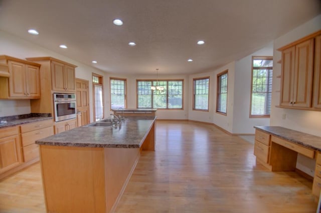 1835 Alpine Pl, Onalaska, WI 54650 - kitchen featuring stainless steel oven, a sink, recessed lighting, light wood-style floors, and dark countertops