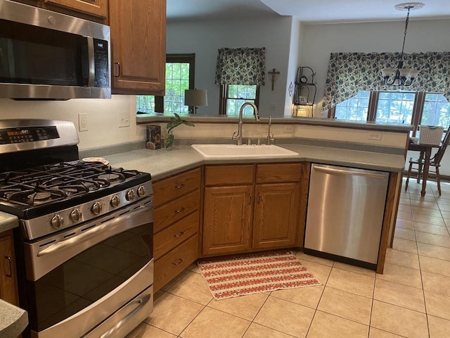 1430 Sherwood Ct, Wisconsin Rapids, WI 54494 - kitchen with stainless steel appliances, a sink, a peninsula, a chandelier, and light tile patterned floors