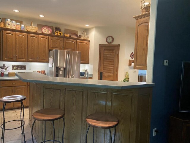 1430 Sherwood Ct, Wisconsin Rapids, WI 54494 - kitchen featuring stainless steel fridge with ice dispenser, a breakfast bar area, light tile patterned flooring, recessed lighting, and a sink