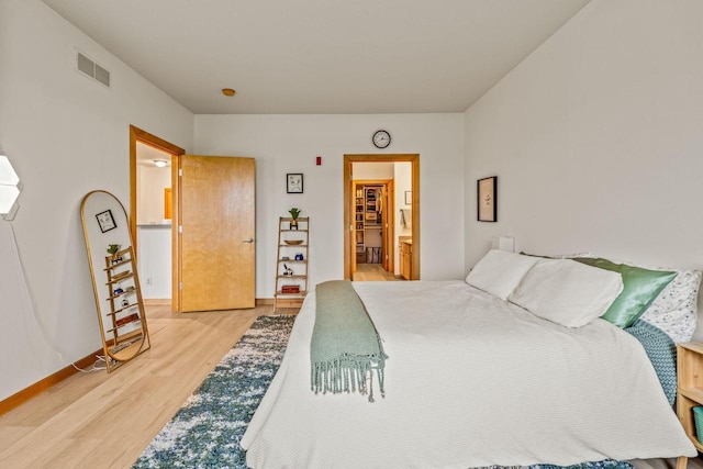 10900 W Bluemound Rd Unit 310, Wauwatosa, WI 53226 - bedroom featuring light wood finished floors, baseboards, and ensuite bath