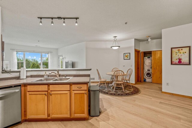 10900 W Bluemound Rd Unit 310, Wauwatosa, WI 53226 - kitchen with dishwasher, a sink, stacked washing machine and dryer, a peninsula, and light wood finished floors