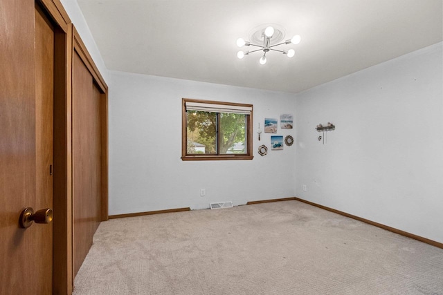 1037 S Union St, Shawano, WI 54166 - unfurnished bedroom featuring a closet, a chandelier, light carpet, and baseboards