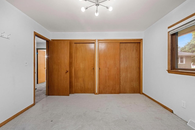 1037 S Union St, Shawano, WI 54166 - unfurnished bedroom featuring light carpet, a chandelier, multiple closets, and baseboards