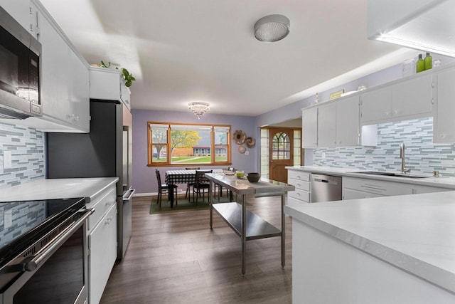 1037 S Union St, Shawano, WI 54166 - kitchen with stainless steel appliances, a sink, light countertops, backsplash, and white cabinets