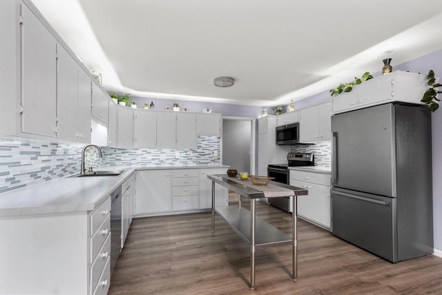 1037 S Union St, Shawano, WI 54166 - kitchen with stainless steel appliances, a sink, backsplash, light countertops, and white cabinets