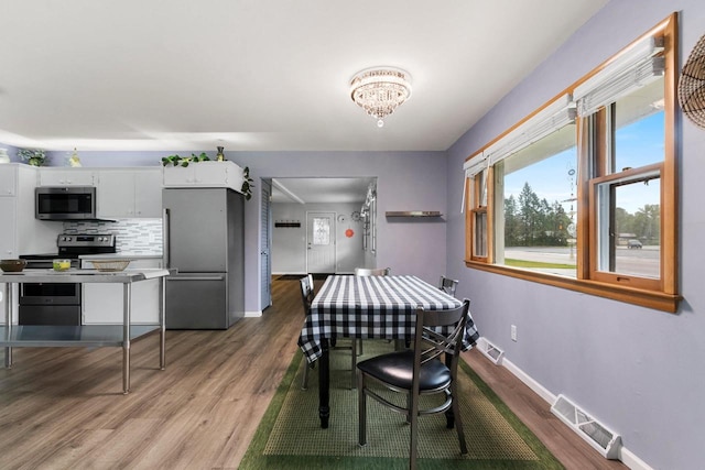 1037 S Union St, Shawano, WI 54166 - dining room featuring wood finished floors, baseboards, and a chandelier