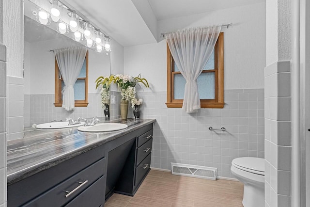 1037 S Union St, Shawano, WI 54166 - full bathroom with tile walls, vanity, toilet, tile patterned floors, and a wainscoted wall