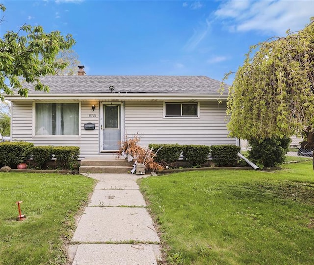 8721 W Douglas Ave, Milwaukee, WI 53225 - view of front of property with a front yard, a chimney, and a shingled roof