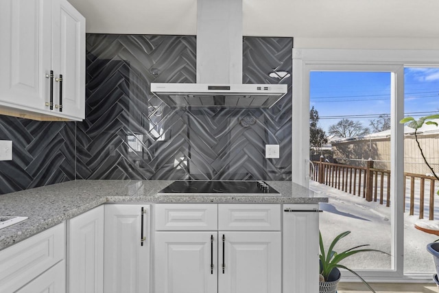 8721 W Douglas Ave, Milwaukee, WI 53225 - kitchen featuring wall chimney exhaust hood, tasteful backsplash, white cabinets, and black electric stovetop