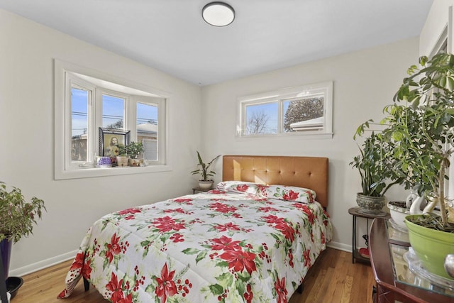 8721 W Douglas Ave, Milwaukee, WI 53225 - bedroom featuring multiple windows, wood finished floors, and baseboards