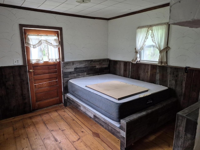 N3922 11th Ave, Hancock, WI 54943 - bedroom with a wainscoted wall, wood walls, ornamental molding, and light wood-type flooring