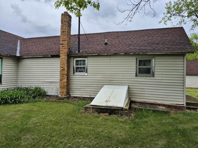 N3922 11th Ave, Hancock, WI 54943 - rear view of property featuring roof with shingles, a yard, and a chimney