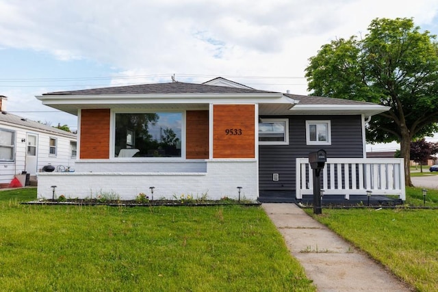 9533 W Silver Spring Dr, Milwaukee, WI 53225 - view of front of home featuring a front yard, a porch, brick siding, and a shingled roof