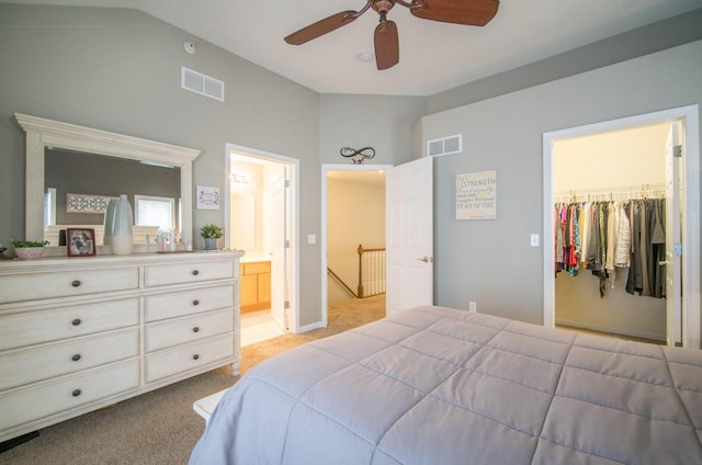 739 Shore Ln, West Bend, WI 53090 - bedroom with light carpet, a walk in closet, lofted ceiling, connected bathroom, and ceiling fan