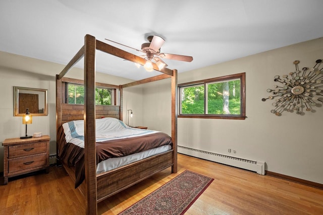 1104 Cavalier Dr, Waukesha, WI 53186 - bedroom with a baseboard radiator, multiple windows, wood finished floors, and ceiling fan