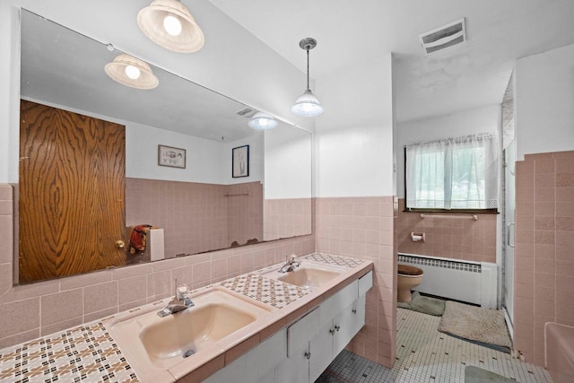 1104 Cavalier Dr, Waukesha, WI 53186 - bathroom with radiator heating unit, tile walls, double vanity, toilet, and tile patterned flooring