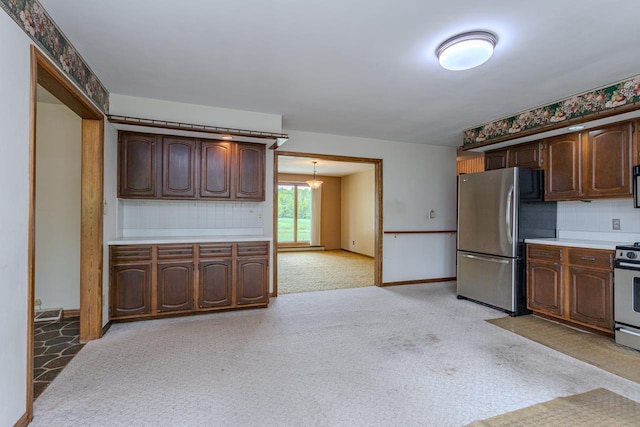 419 E Beech St, Edgar, WI 54426 - kitchen with appliances with stainless steel finishes, light countertops, light carpet, tasteful backsplash, and baseboards