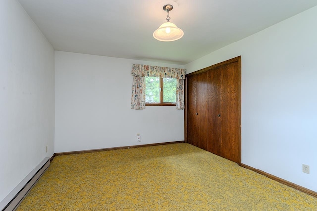 419 E Beech St, Edgar, WI 54426 - unfurnished bedroom with a baseboard heating unit, a closet, baseboards, and carpet flooring