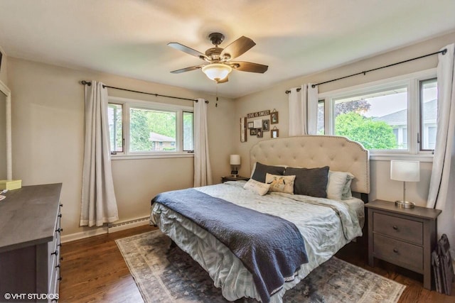 2590 S 91st St, West Allis, WI 53227 - bedroom with dark wood finished floors, baseboard heating, baseboards, and a ceiling fan