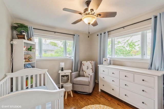 2590 S 91st St, West Allis, WI 53227 - bedroom with multiple windows, wood finished floors, a crib, and ceiling fan