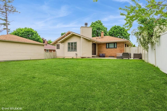 2590 S 91st St, West Allis, WI 53227 - back of property with a chimney, brick siding, a patio, and an outdoor hangout area