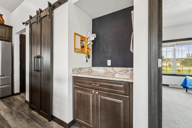 3815 Stone Wall Dr, De Pere, WI 54115 - bar with freestanding refrigerator, a barn door, baseboards, dark carpet, and dark wood-style flooring