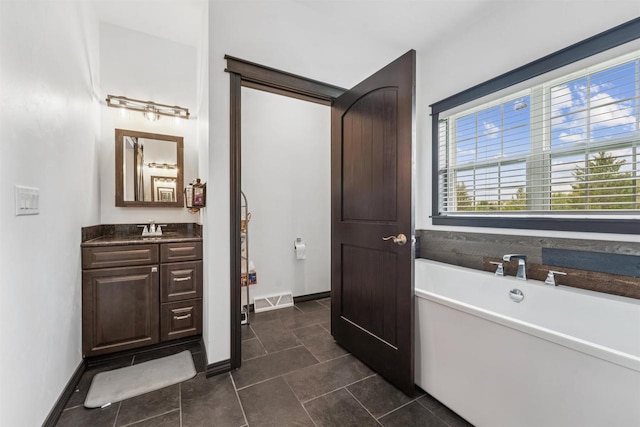 3815 Stone Wall Dr, De Pere, WI 54115 - bathroom with a freestanding tub, vanity, tile patterned floors, and baseboards