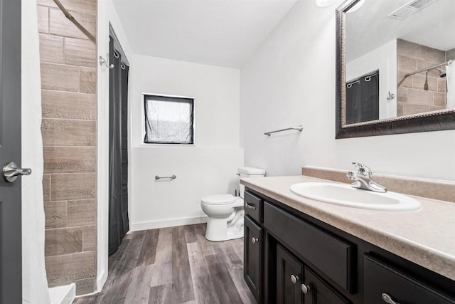 3815 Stone Wall Dr, De Pere, WI 54115 - bathroom featuring vanity, a tile shower, toilet, and wood finished floors