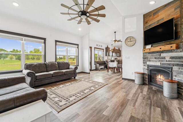 3815 Stone Wall Dr, De Pere, WI 54115 - living room featuring a ceiling fan, vaulted ceiling, a glass covered fireplace, wood finished floors, and recessed lighting