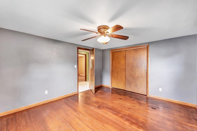 1945 Eastman Ave, Green Bay, WI 54302 - unfurnished bedroom featuring light wood-type flooring, baseboards, a ceiling fan, and a closet