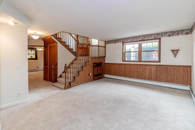 N2594 State Road 76, Hortonville, WI 54944 - unfurnished living room featuring a wainscoted wall, stairway, wooden walls, carpet floors, and a baseboard heating unit