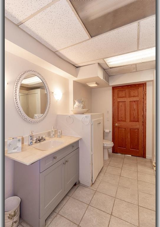 N2594 State Road 76, Hortonville, WI 54944 - bathroom with a drop ceiling, vanity, tile patterned floors, and toilet
