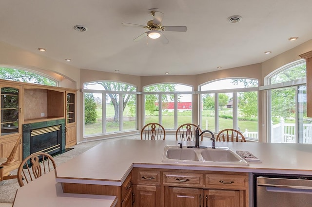 N2594 State Road 76, Hortonville, WI 54944 - kitchen with stainless steel dishwasher, a sink, a ceiling fan, a fireplace with flush hearth, and light countertops