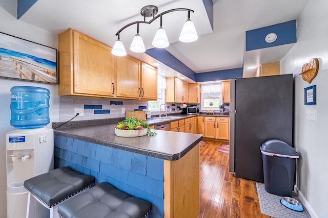 201 N 3rd St, Colby, WI 54421 - kitchen featuring stainless steel appliances, a peninsula, dark countertops, dark wood-style floors, and light brown cabinets