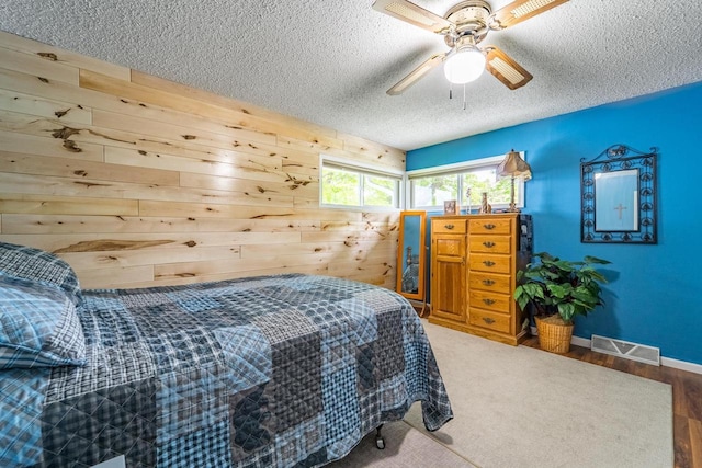 201 N 3rd St, Colby, WI 54421 - bedroom with a textured ceiling, wooden walls, ceiling fan, wood finished floors, and baseboards