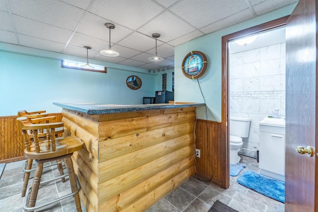 201 N 3rd St, Colby, WI 54421 - indoor dry bar with wainscoting, a drop ceiling, wood walls, and decorative light fixtures