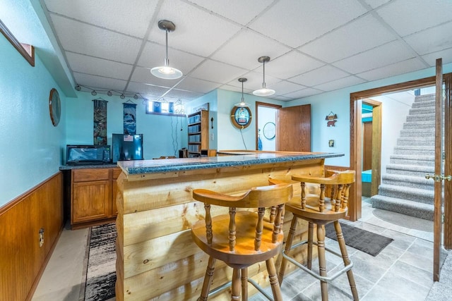 201 N 3rd St, Colby, WI 54421 - indoor bar featuring a drop ceiling, stairway, a wainscoted wall, wood walls, and decorative light fixtures