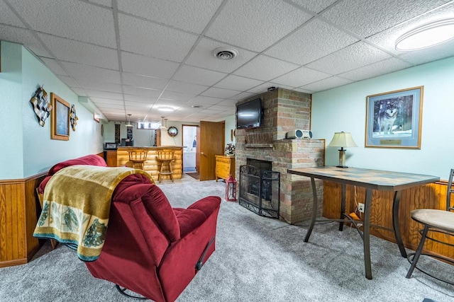 201 N 3rd St, Colby, WI 54421 - carpeted living area with a dry bar, a drop ceiling, wooden walls, a wainscoted wall, and a fireplace