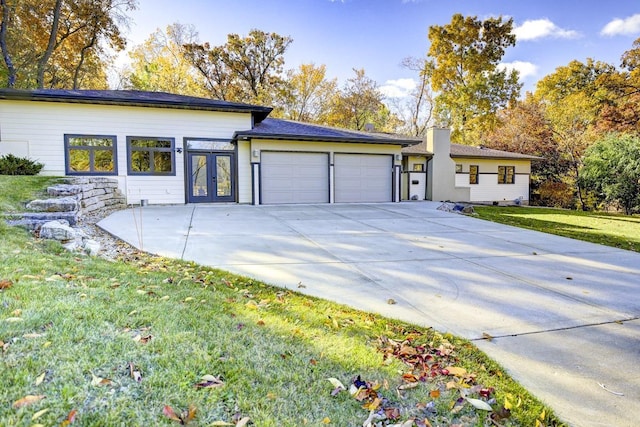 508 Frost Woods Rd, Monona, WI 53716 - single story home with an attached garage, french doors, a front lawn, driveway, and a chimney