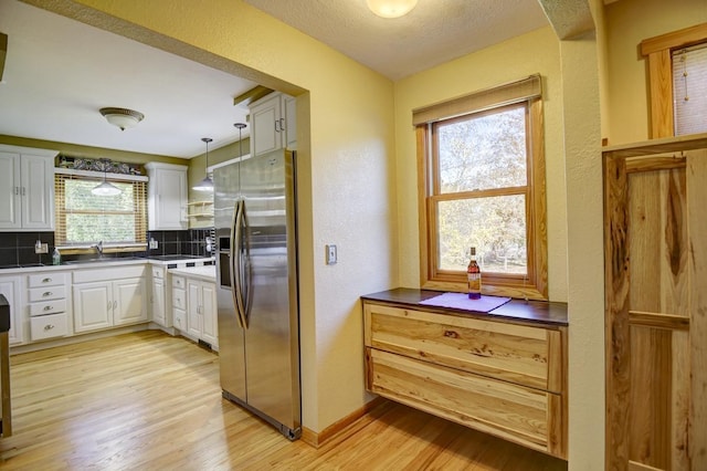 508 Frost Woods Rd, Monona, WI 53716 - kitchen with stainless steel refrigerator with ice dispenser, tasteful backsplash, a textured wall, light wood finished floors, and a sink