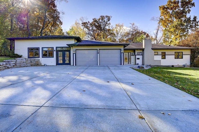 508 Frost Woods Rd, Monona, WI 53716 - mid-century home with a garage, a chimney, concrete driveway, french doors, and a front lawn