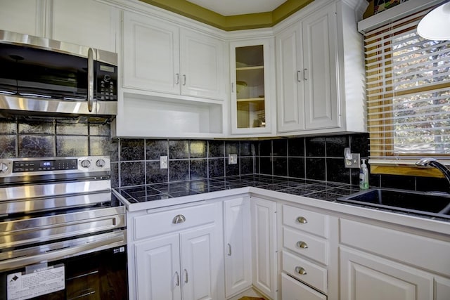 508 Frost Woods Rd, Monona, WI 53716 - kitchen with appliances with stainless steel finishes, white cabinets, a sink, and backsplash