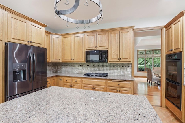 W313N4961 Chapel Ridge Rd, Hartland, WI 53029 - kitchen with black appliances, light stone countertops, decorative backsplash, and light wood-style floors