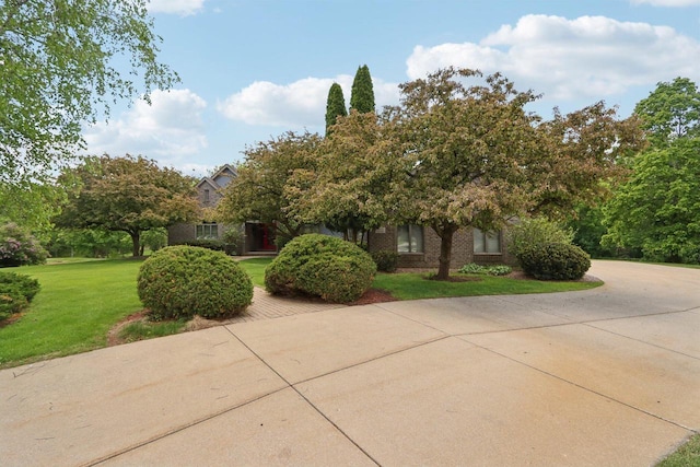W313N4961 Chapel Ridge Rd, Hartland, WI 53029 - view of property hidden behind natural elements featuring a front lawn, curved driveway, and brick siding